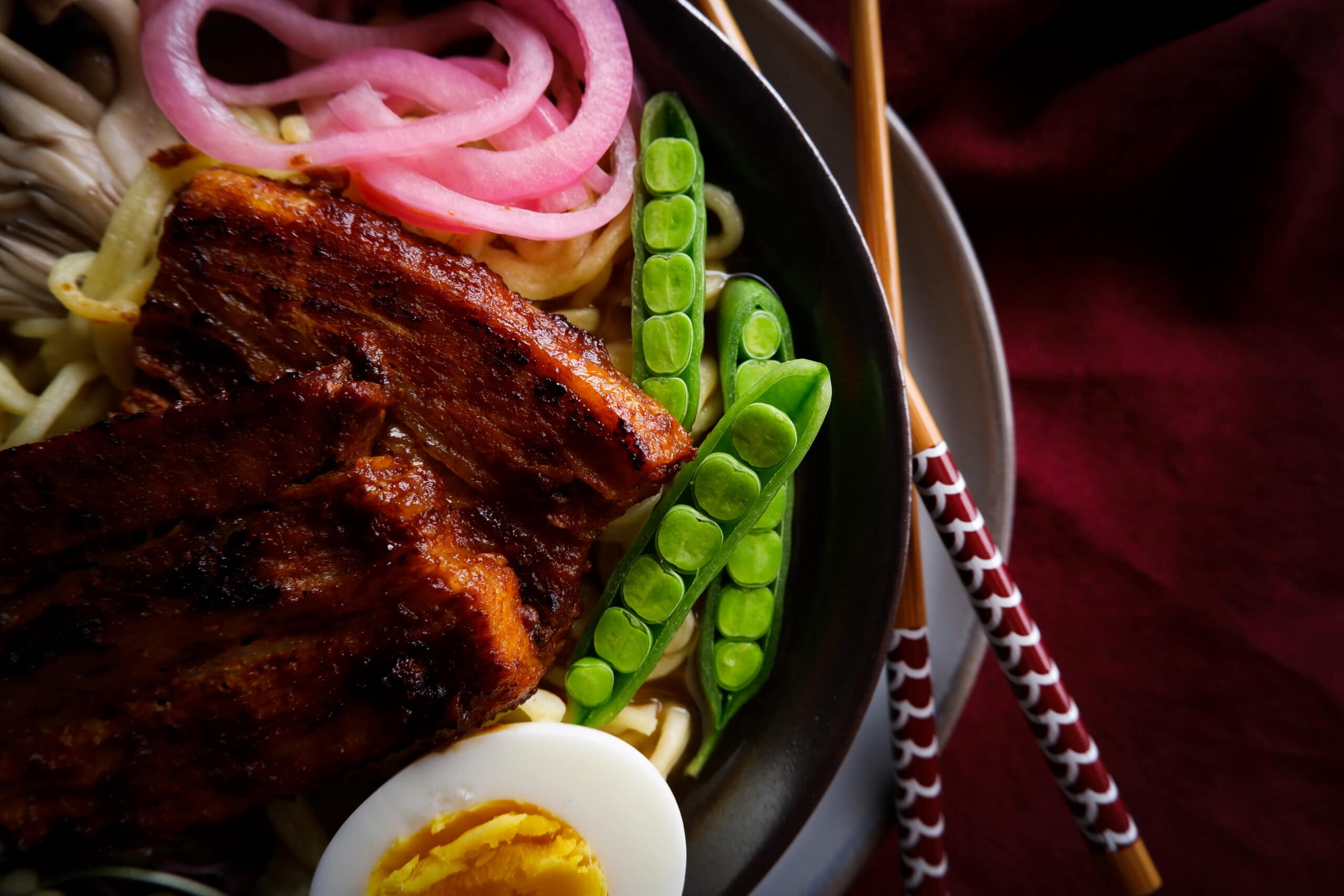 pork belly ramen with pickled onions and snap peas.