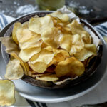 potato chips in bowl with some spilling out.