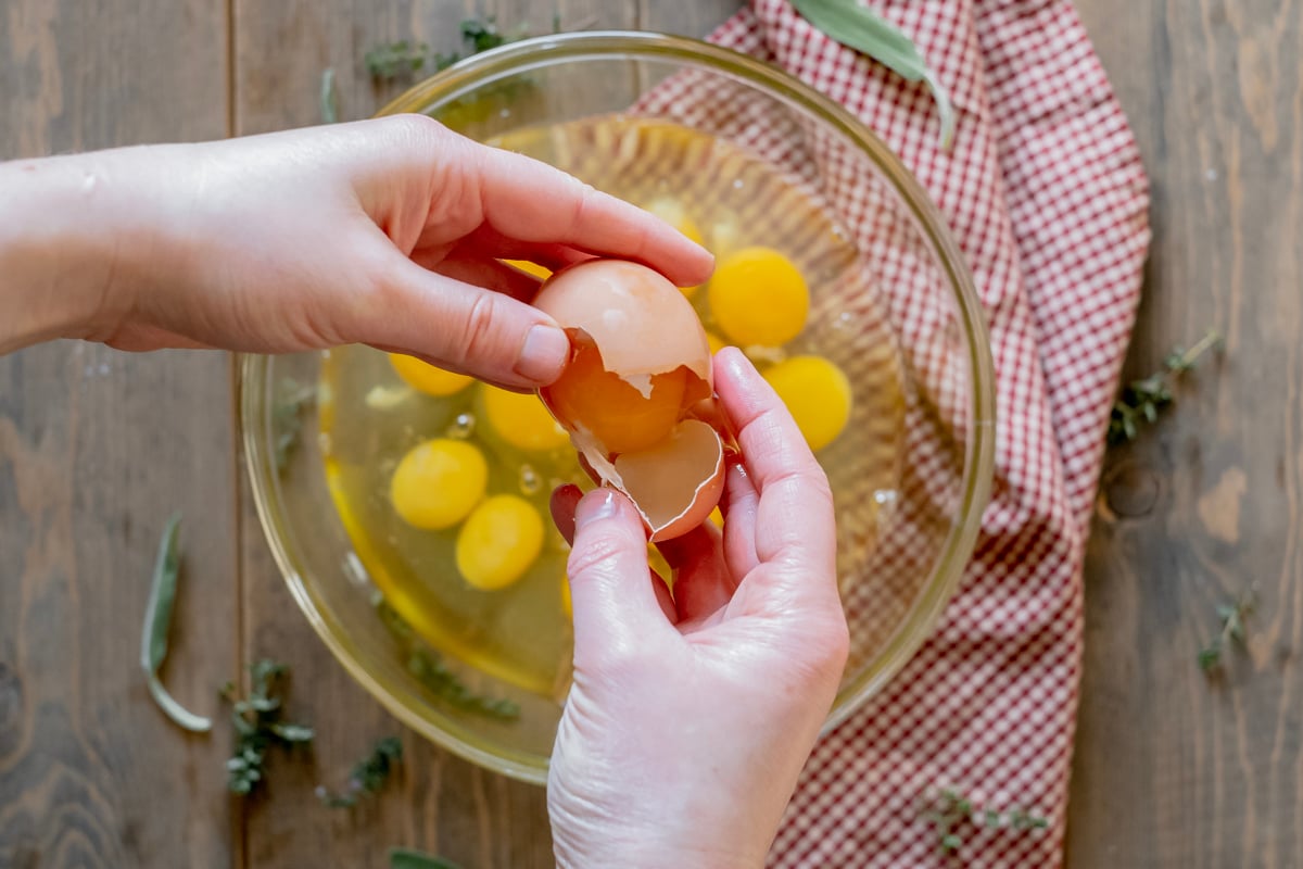 cracking eggs into bowl for breakfast strata.