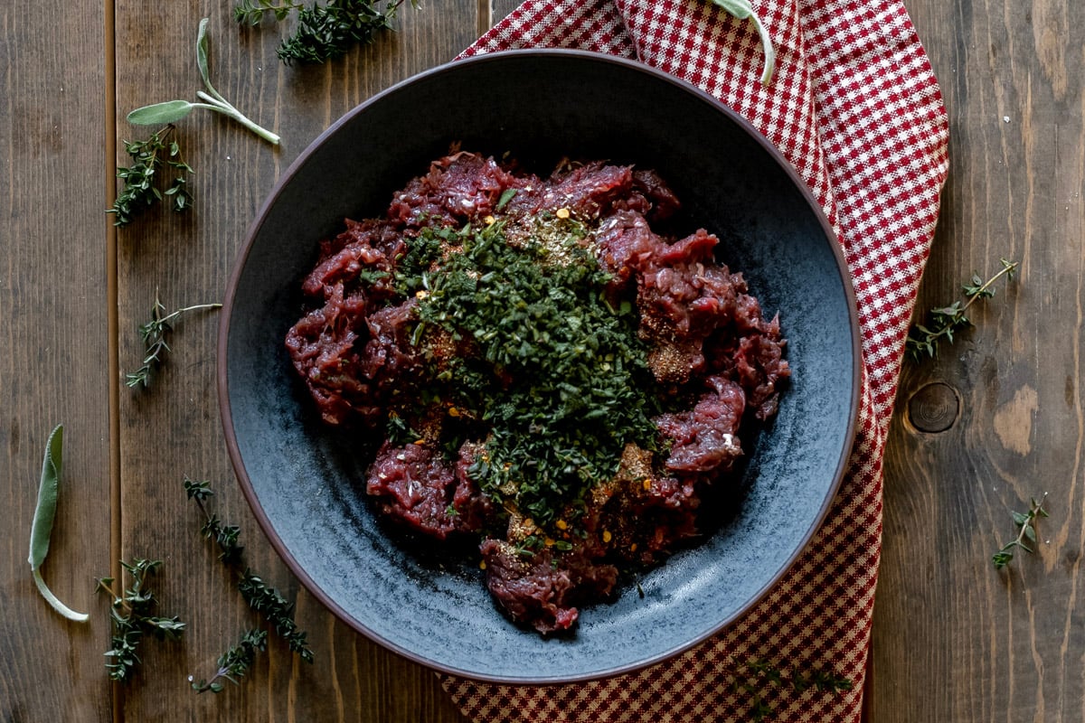 ground meat with herbs and spices in bowl.