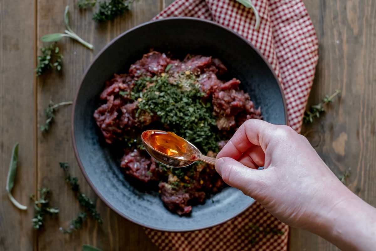 pouring maple syrup onto antelope breakfast sausage.
