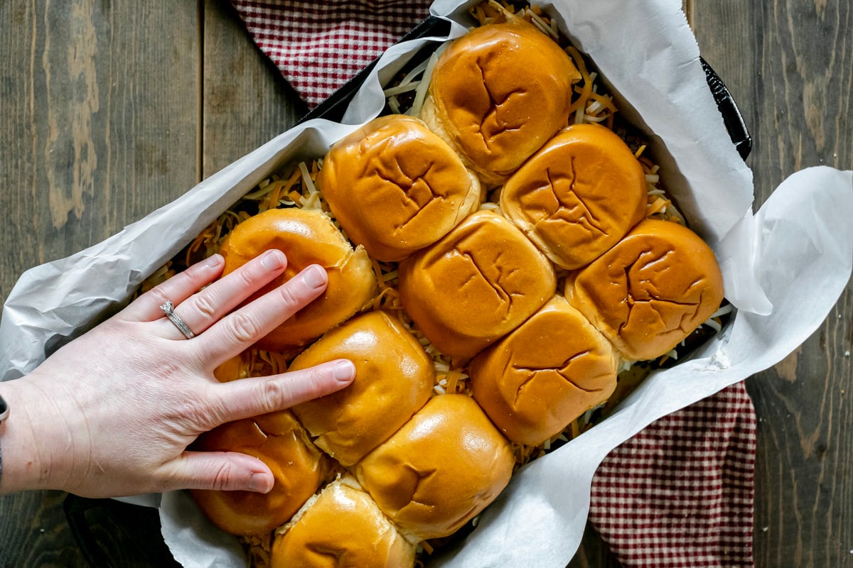 squishing brioche rolls into casserole dish.