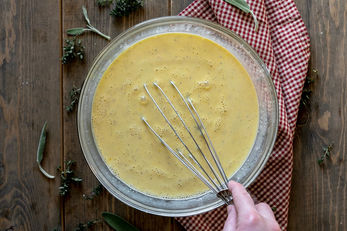 whisking eggs and cream together in bowl.