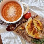 grilled cheese and tomato soup on wood board.