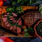 pronghorn carne asada with chimichurri on wood board.