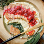 sliced pheasant breast over mashed potatoes with cranberry sauce.