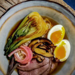 venison ramen with bok choy in blue bowl.