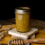 jar of honey mustard dressing with honey dipper.