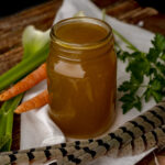open jar of pheasant stock with feathers.