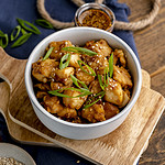 teriyaki halibut bites in bowl on wood boards.