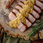 slices of sous vide pork chop with mustard cream sauce.