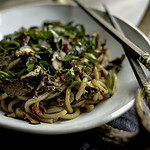 venison stir fry with udon noodles in white bowl with chopsticks.