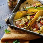 3 grilled halibut tacos with charred corn salsa in square pan.