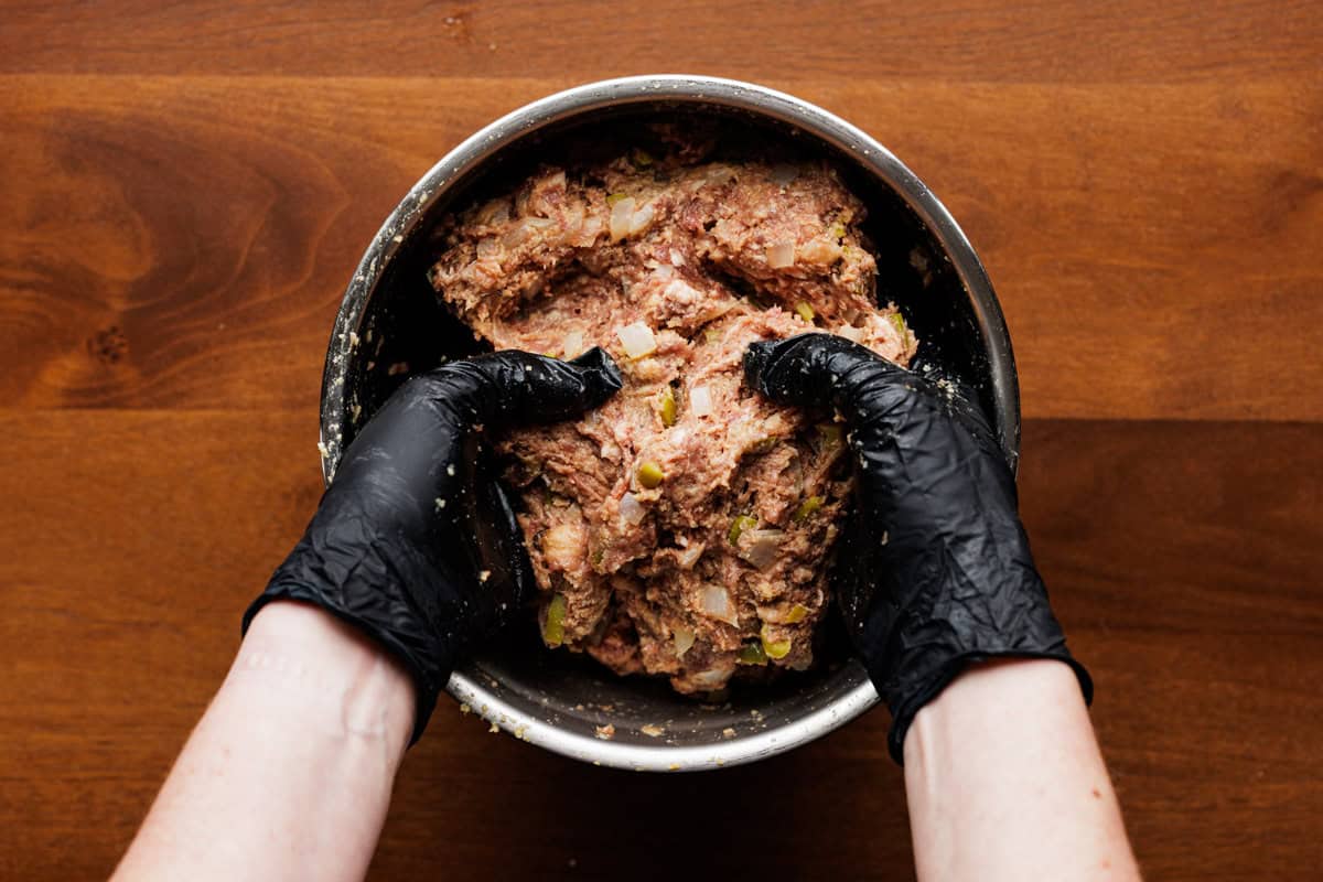 mixing meatloaf mixture with hands.