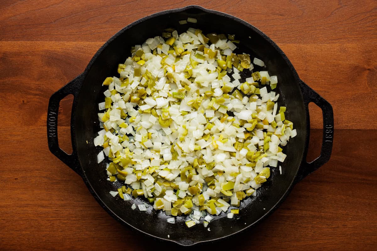 peppers and onions cooking in pan.