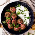 mediterranean venison meatballs in bowl with tzatziki.