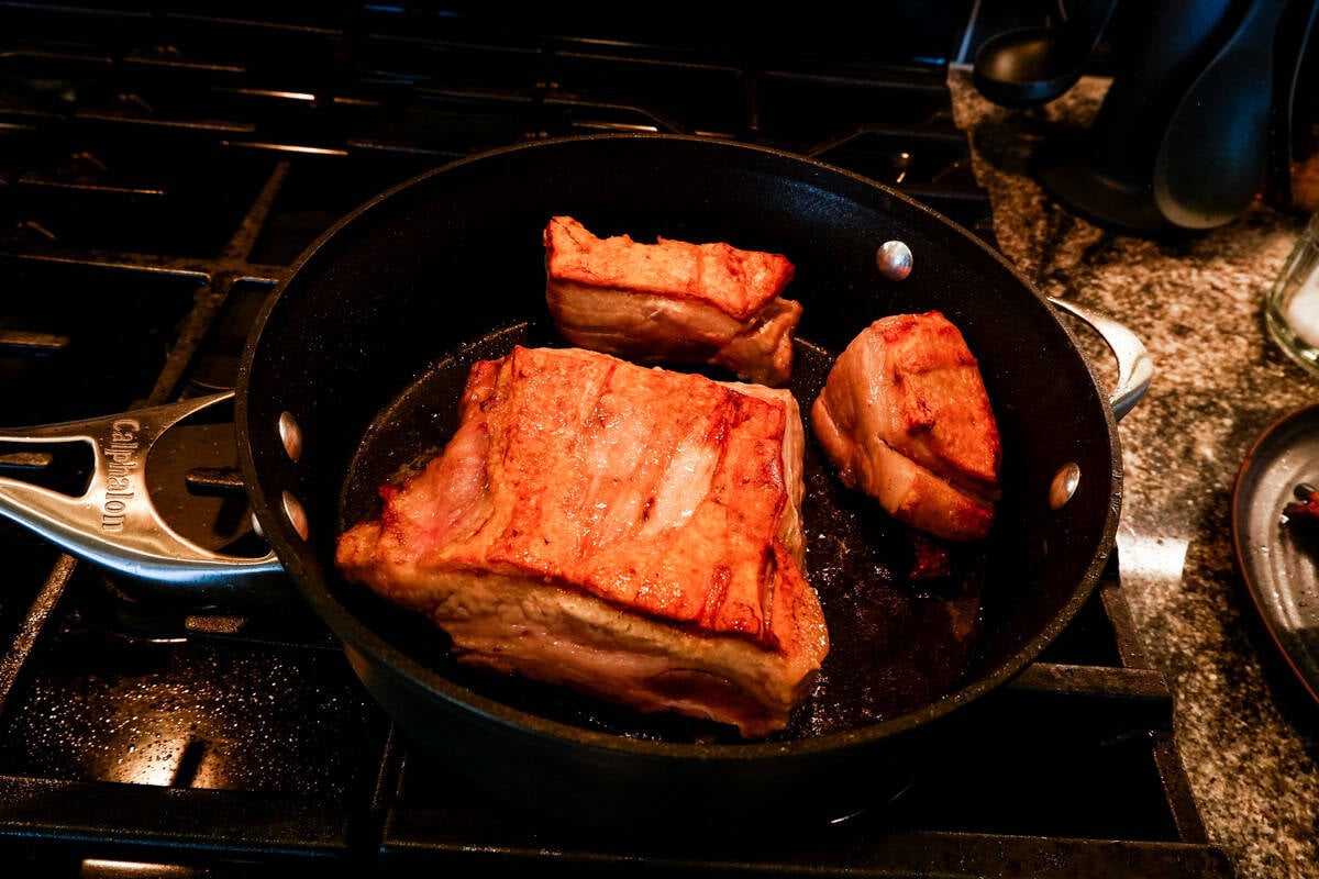 pork belly cooking in pan.
