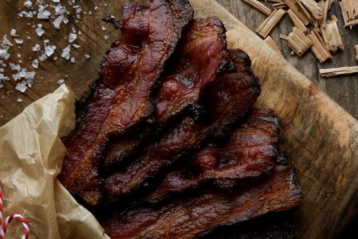 homemade bacon on wood board.