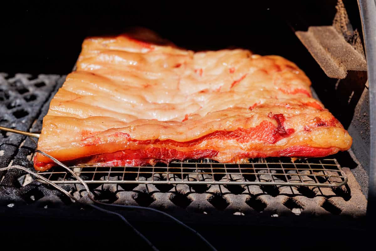 slab of pork belly on pellet smoker.