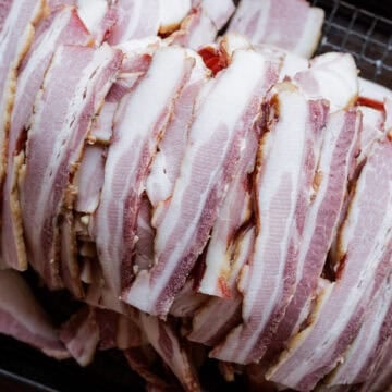 slices of homemade smoked bacon in pile.