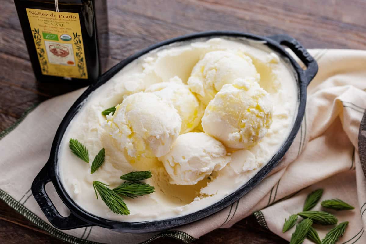 scoops of spruce tip olive oil ice cream in large dish of ice cream.