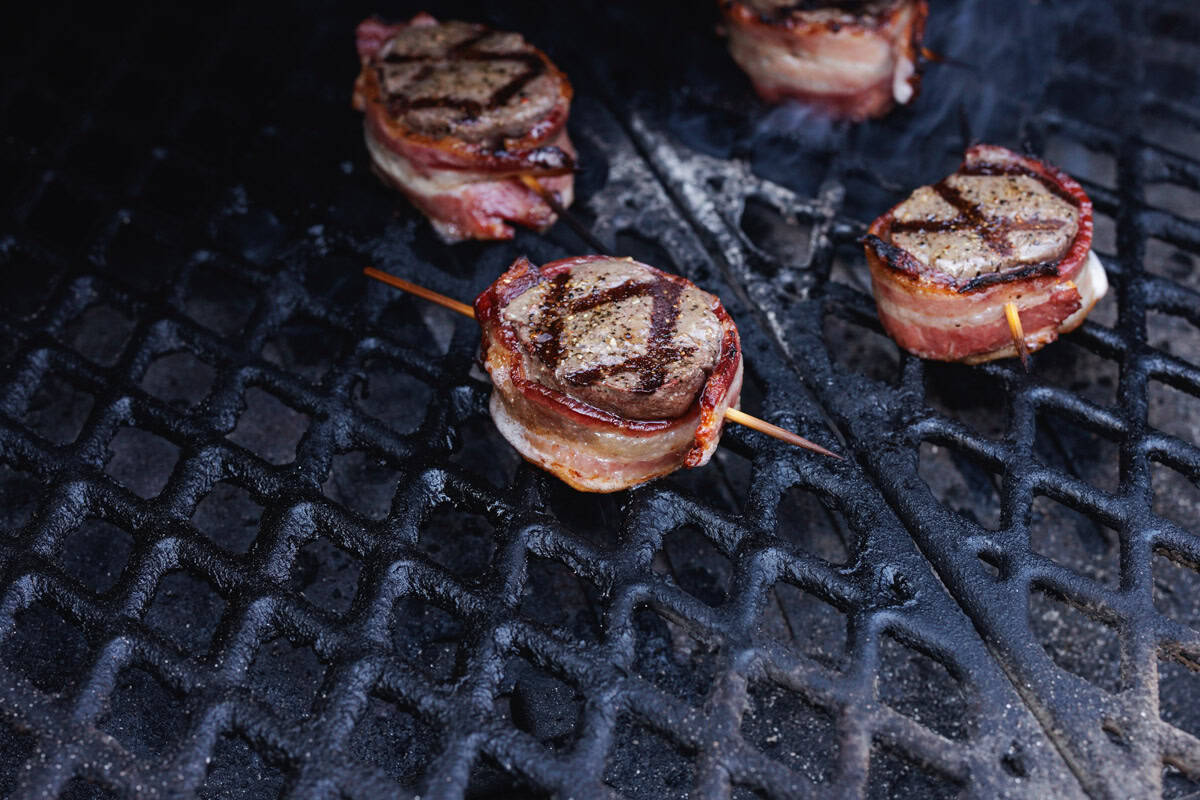 grilling bacon-wrapped venison backstrap medallions.