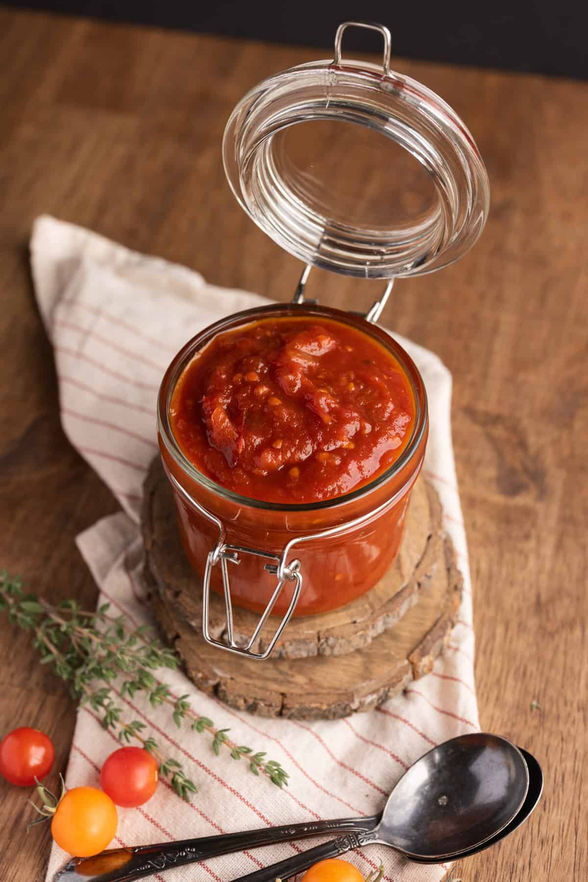 smoked tomato jam in glass jar with spoons.