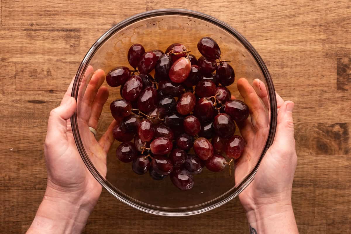 tossing grapes with balsamic vinegar.