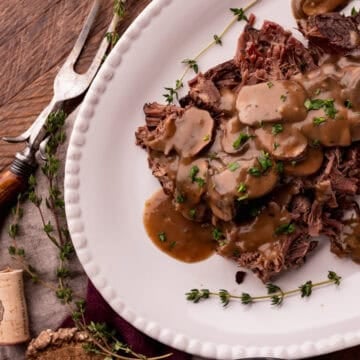 crock pot elk roast on plate with mushroom gravy.