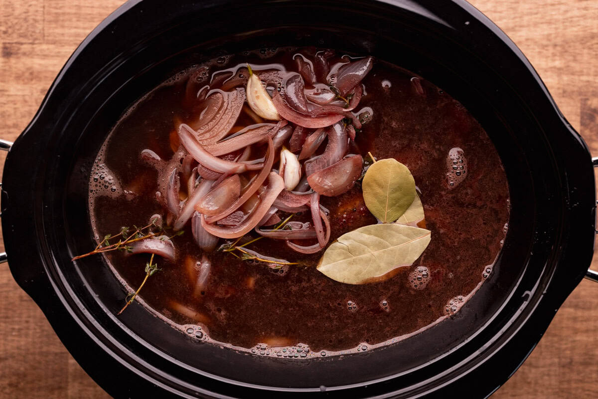crock pot with elk roast in broth.
