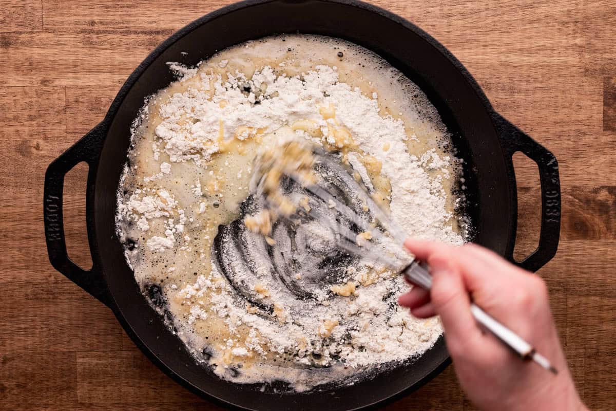 whisking butter with flour in skillet.