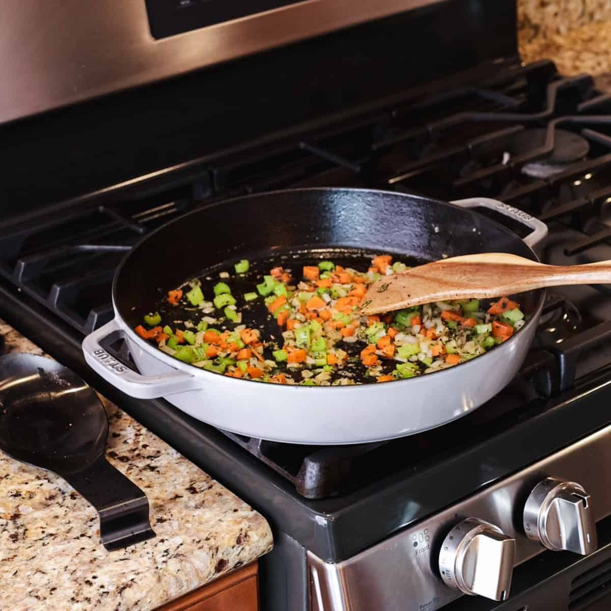 carrots, celery, and onions cooking in skillet.