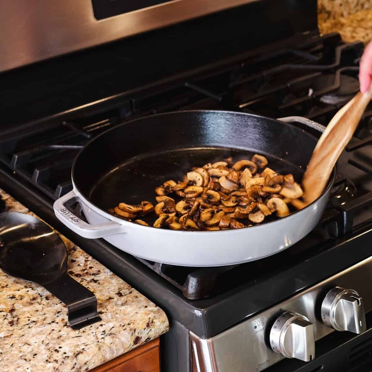 mushrooms cooking in skillet.