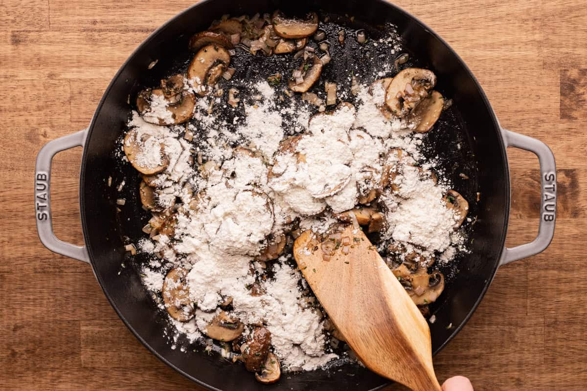 flour on mushrooms in skillet.