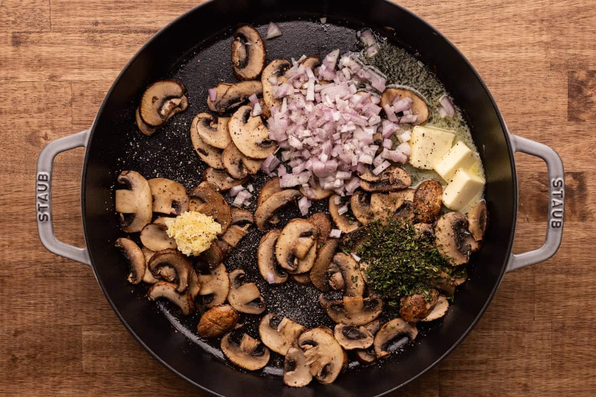 mushrooms with shallots and herbs in skillet.