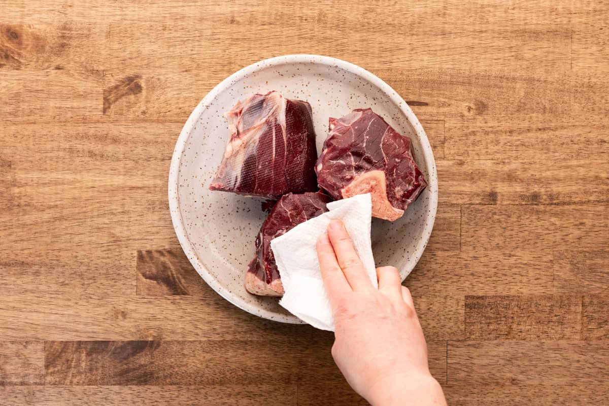 patting elk shanks dry with paper towel.