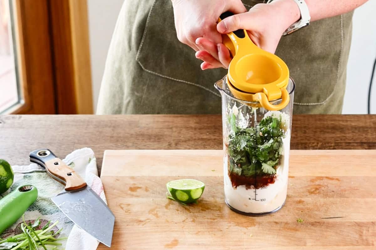 squeezing lime into jar for chipotle lime dressing.