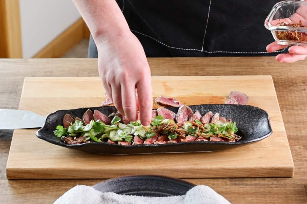 placing cilantro on venison tataki.