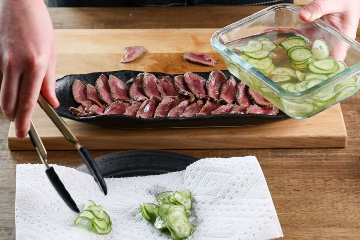 placing pickled cucumbers on paper towel lined plate.