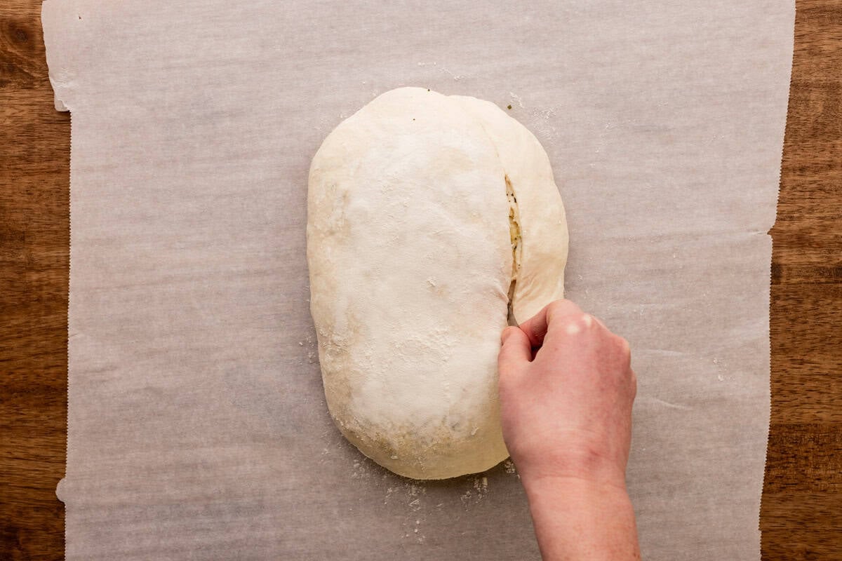 cutting deep slit into side of sourdough loaf.