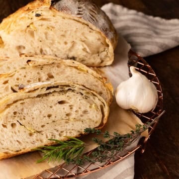 slices of garlic and herb sourdough bread on cooling rack.